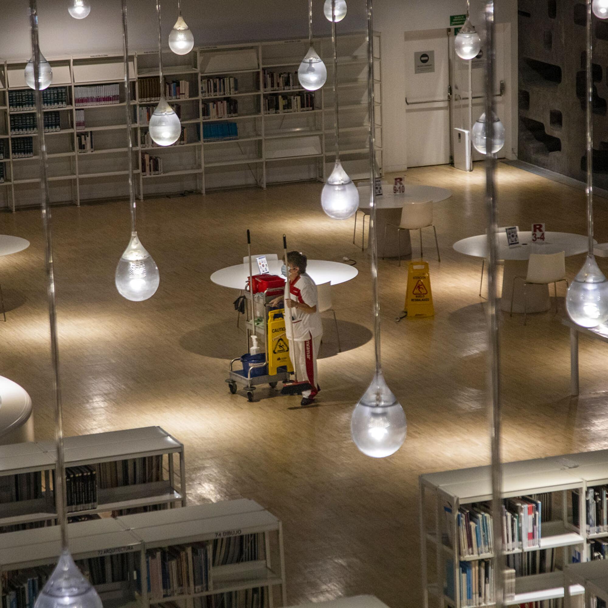 Una trabajadora de la limpieza en una biblioteca