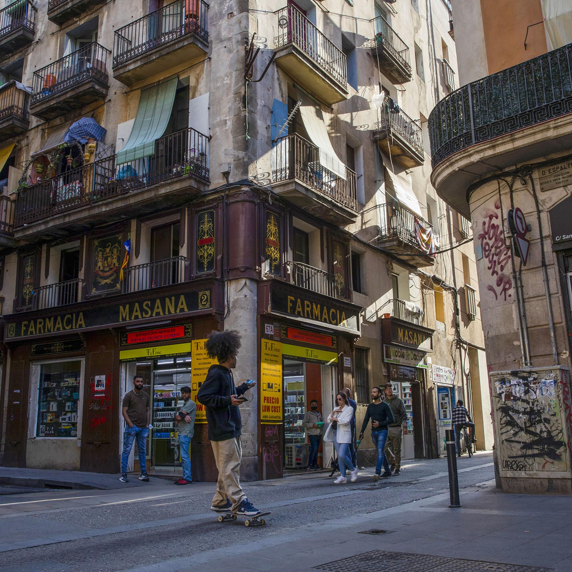 Un chaval en monopatín por el Raval de Barcelona