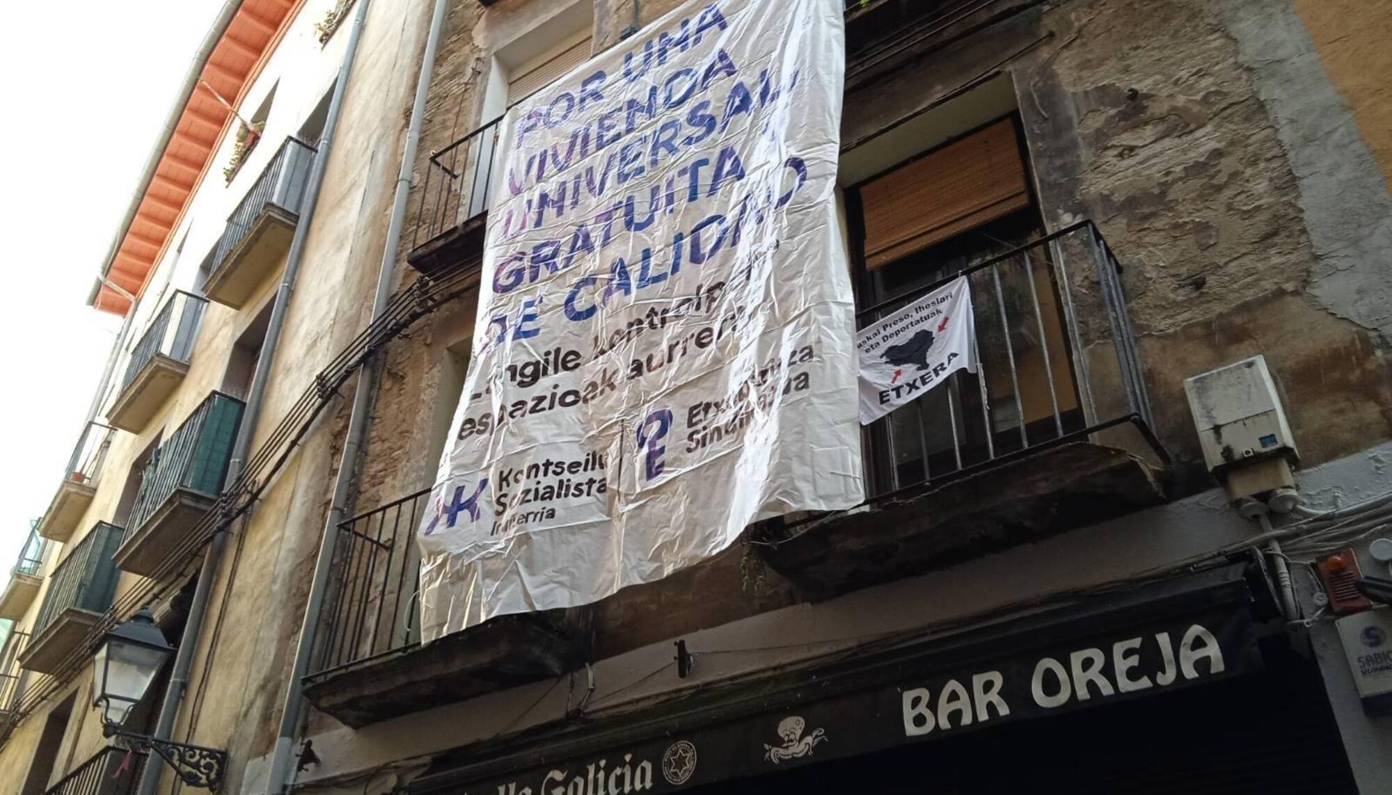 Pancarta cuelga desde los balcones del piso intervenido en calle Jarauta, Pamplona / Konstseilu Sozialista Iruñerria