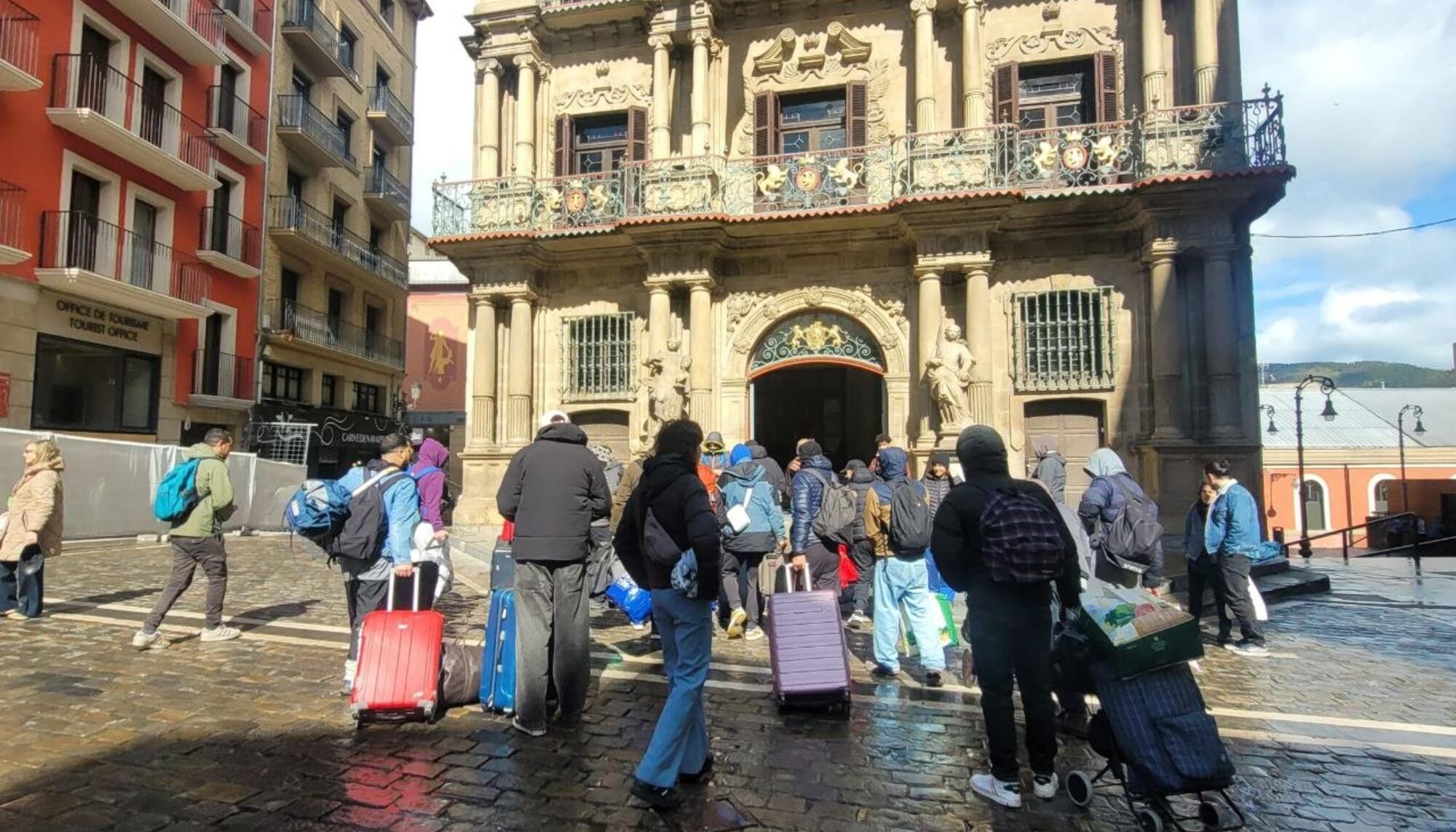 Varias decenas de trabajadores migrantes desalojados de Aranzadi se dirigen al consistorio de Iruñea cargados con sus maletas y enseres