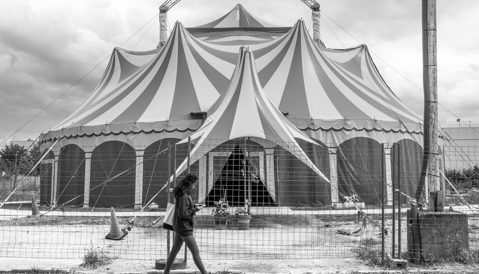 Una niña camina junto a la carpa de circo instalada cerca del barrio de La Noé, en Chanteloup-les-Vignes (Francia)