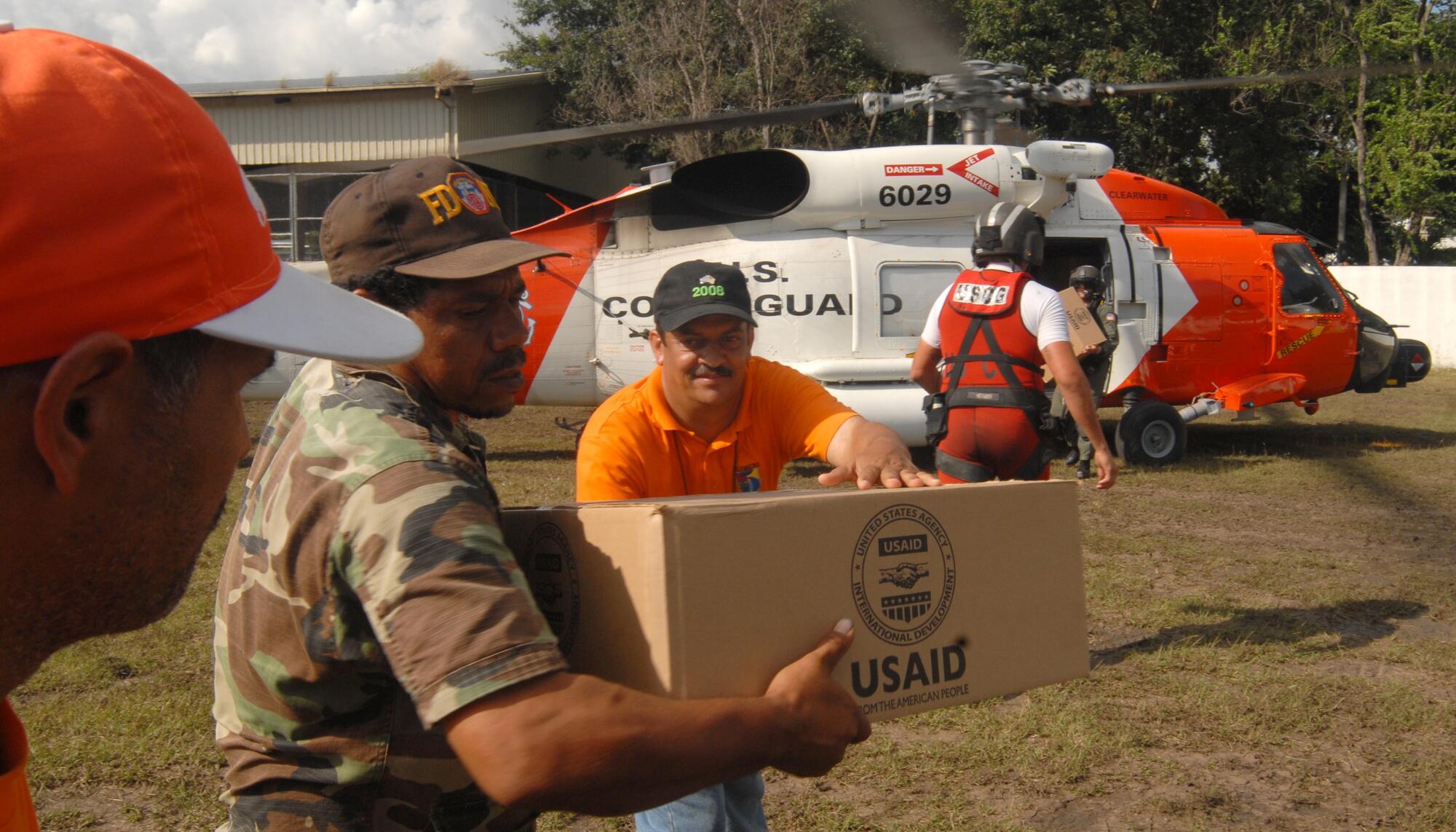 Miembros de la Guardia Costera de Estados Unidos entregando paquetes de la Agencia de Cooperación Internacional para el Desarrollo.