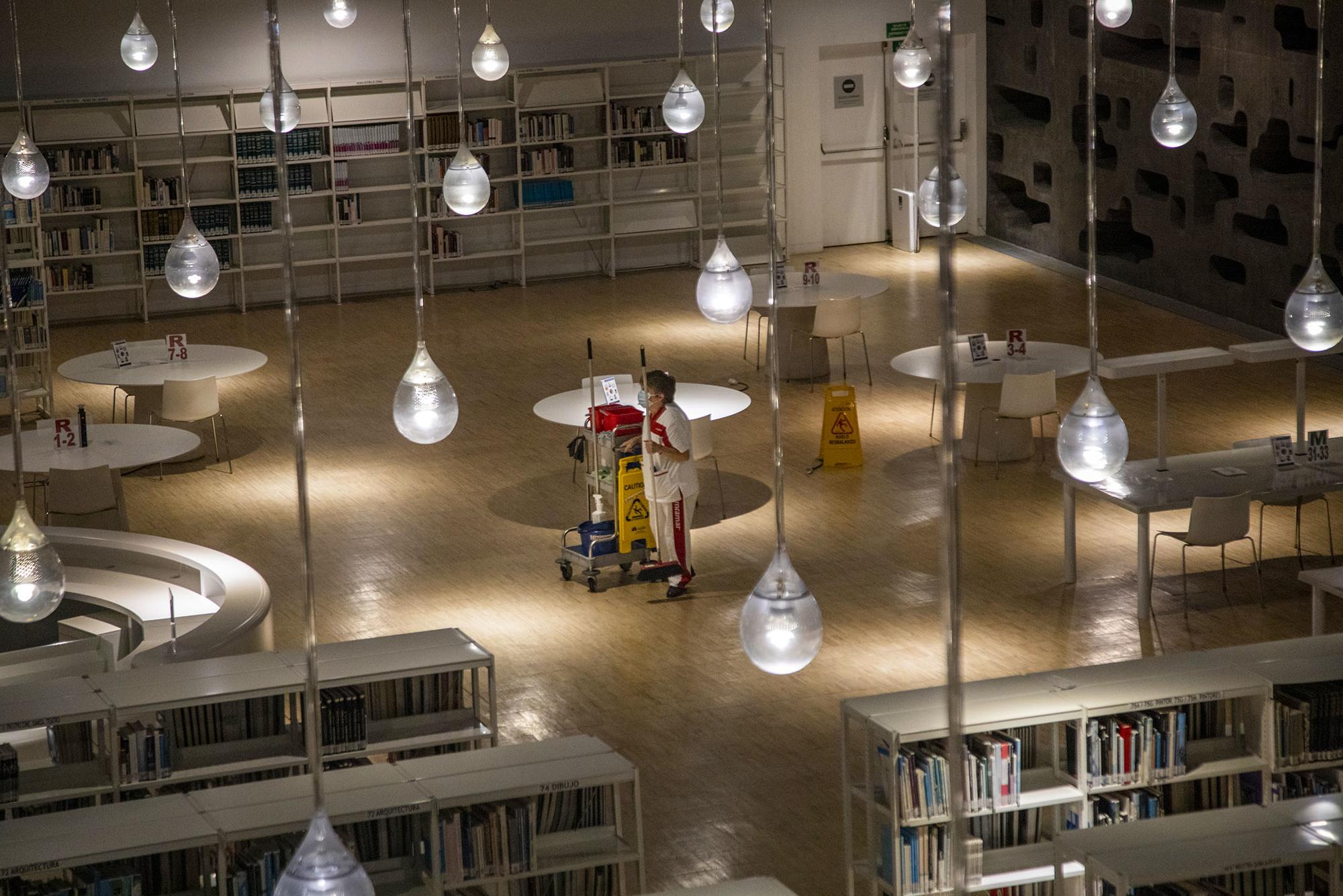 Una trabajadora de la limpieza en una biblioteca