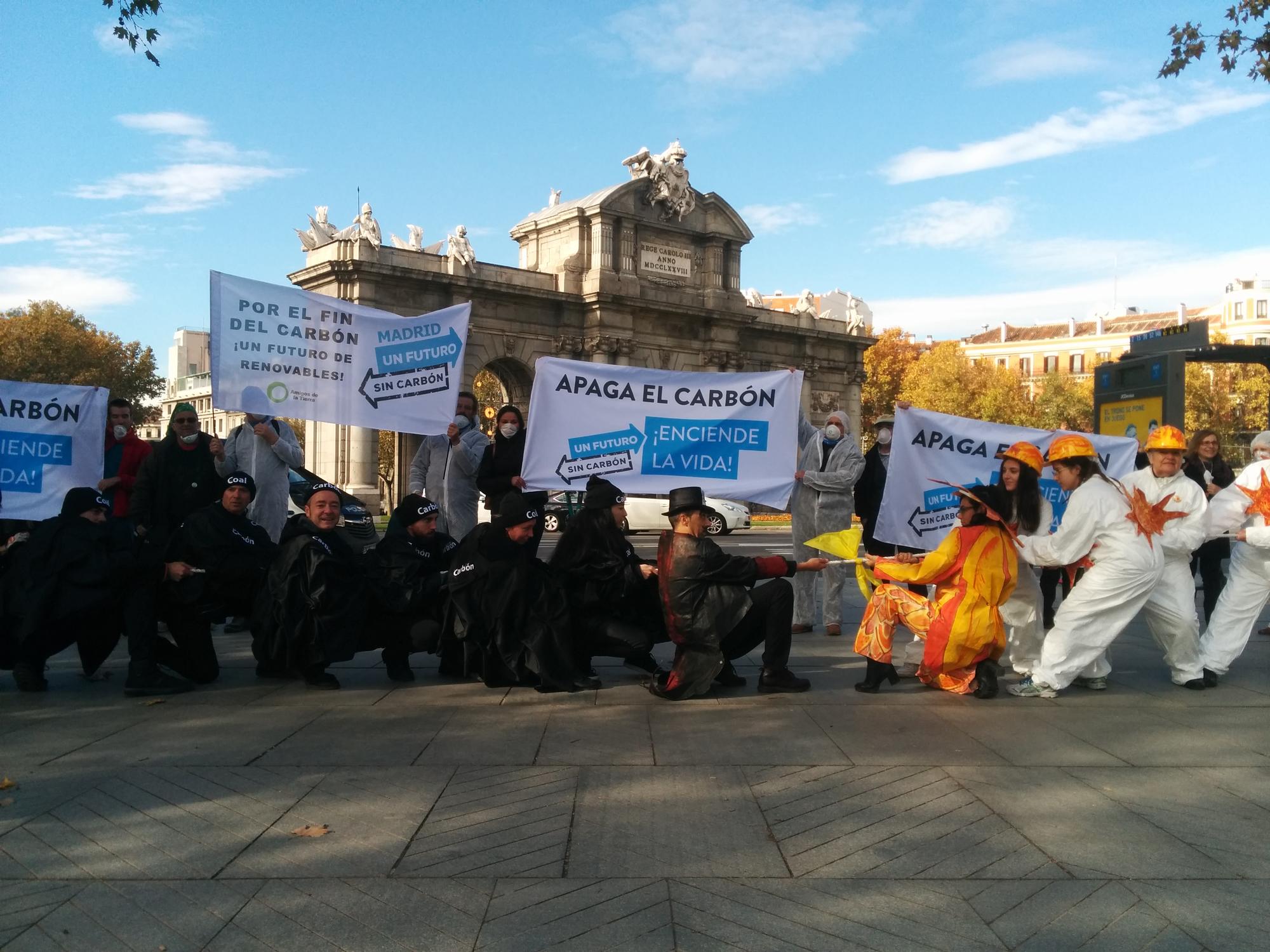 Activistas de la plataforma Un futuro sin carbón piden en Madrid, junto a la Puerta de Alcalá, el fin del carbón