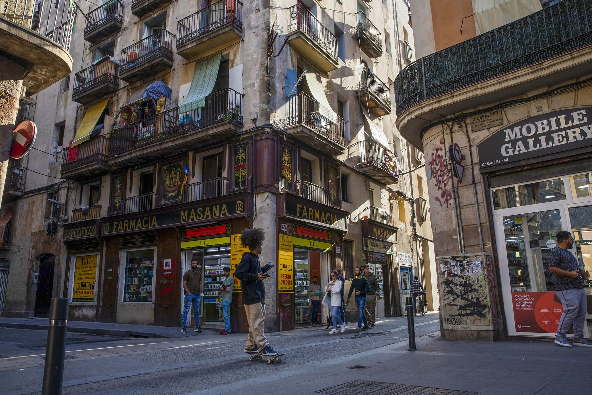Un chaval en monopatín por el Raval de Barcelona
