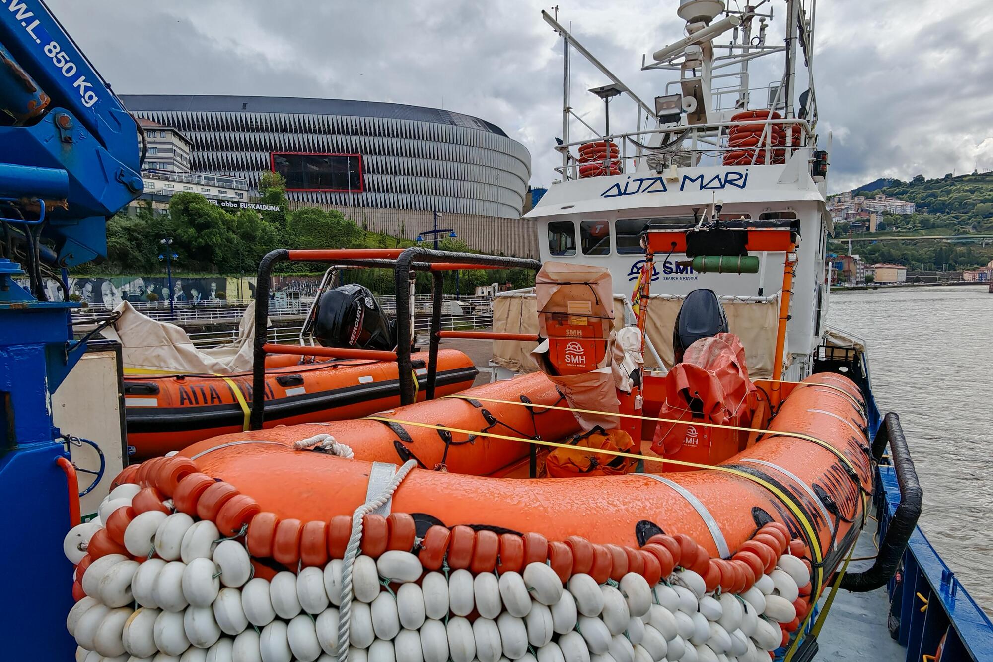 El viejo atunero reconvertido en buque salvavidas atracado en el puerto de Bilbao con San Mamés detrás 