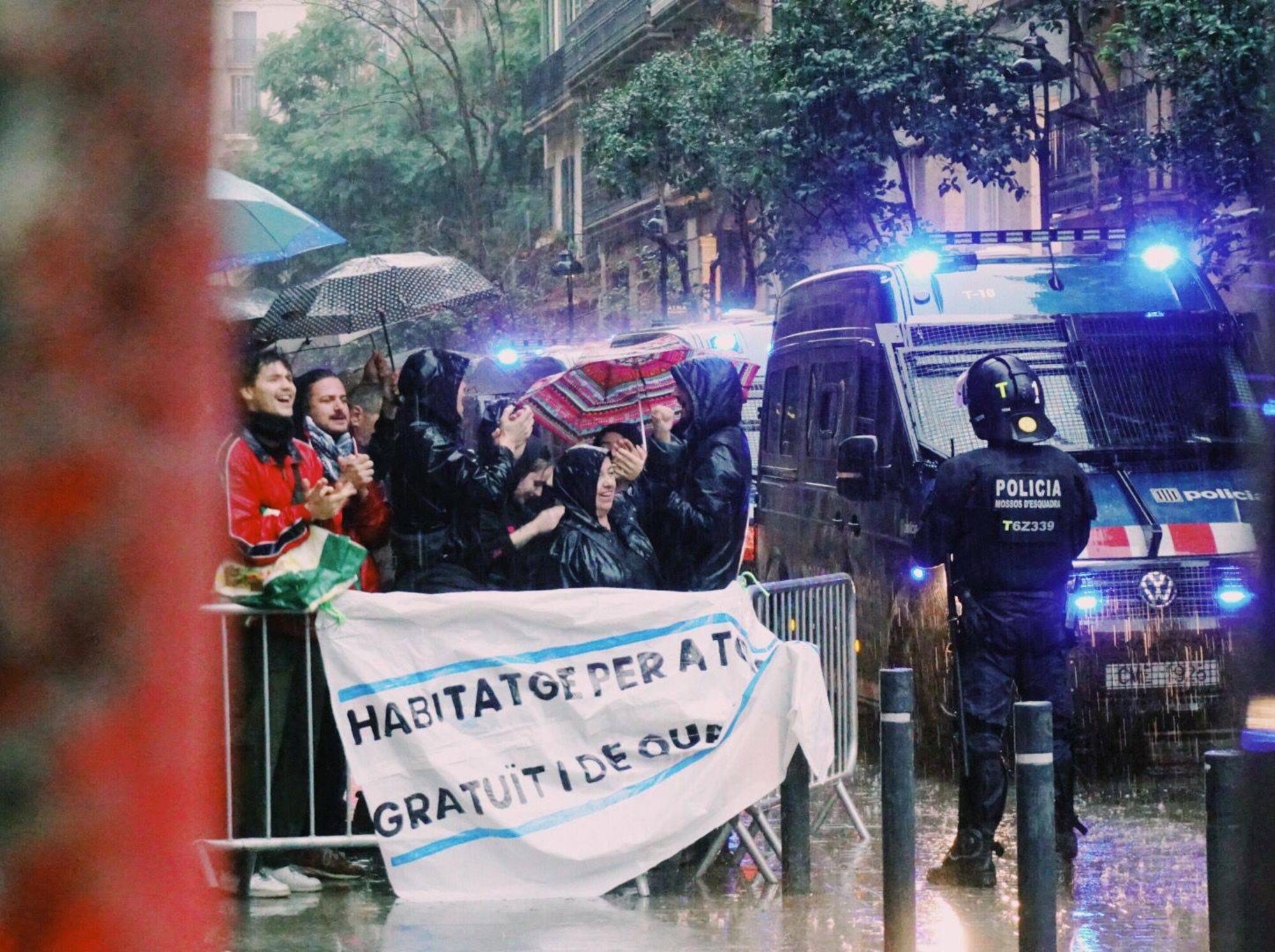 Manifestantes del movimiento de vivienda del Raval protestan por un desahucio de una familia con un menor a cargo en plena alerta roja por tormentas.