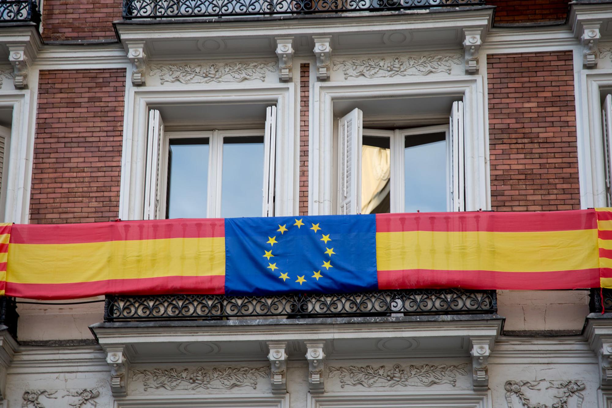 Fachada con banderas de Cataluña, España y Europa. Madrid.