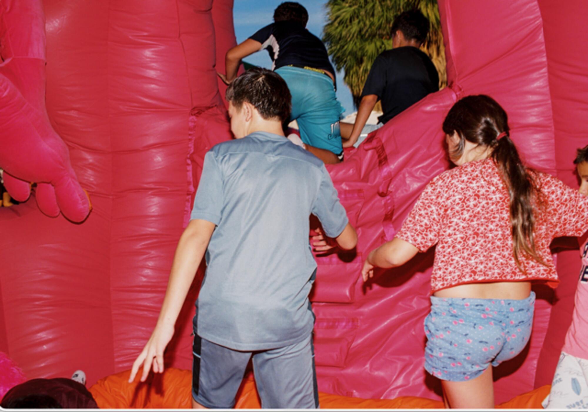 Niños jugando con la escultura hinchable