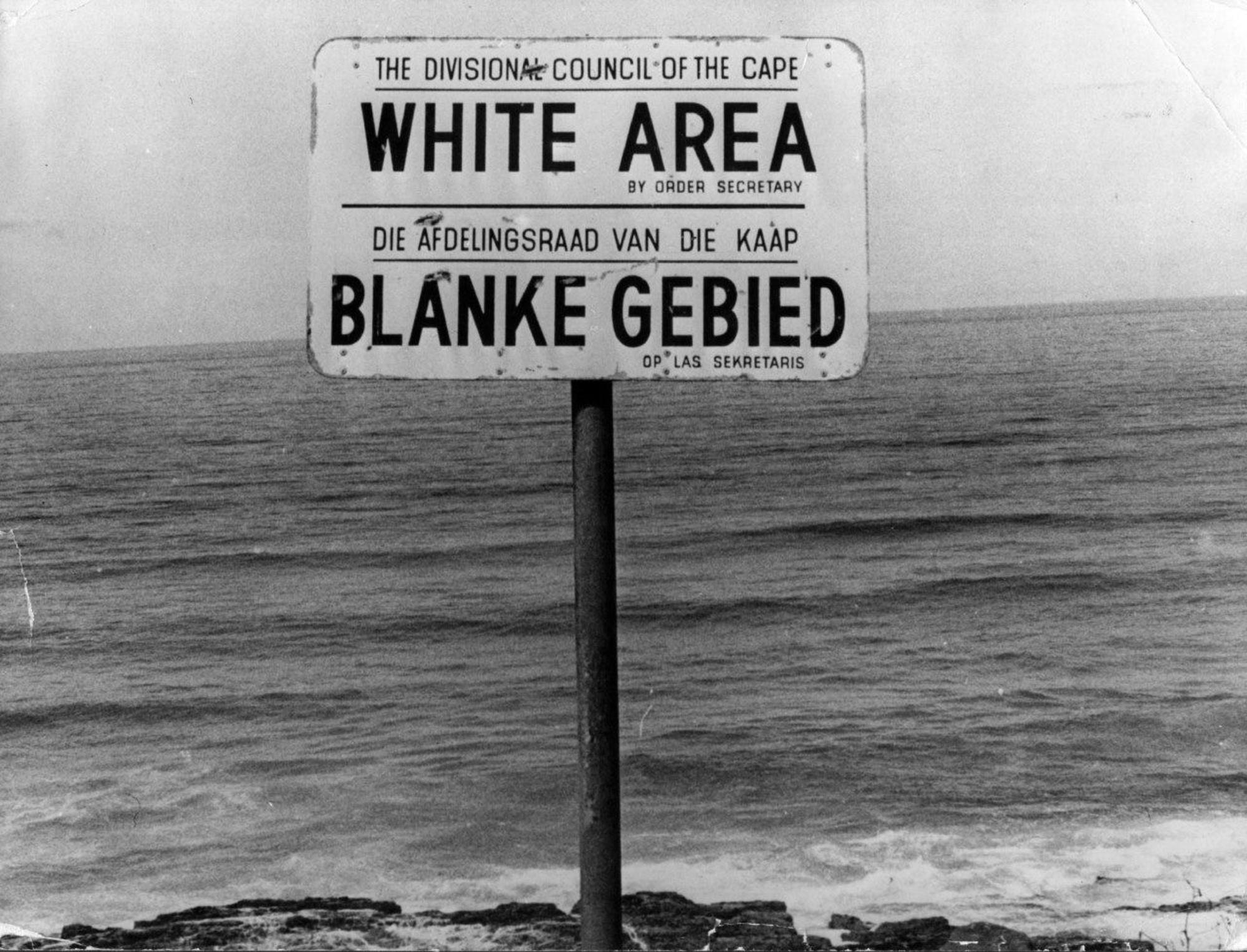 Cartel del régimen sudafricano indicando un área acotada a población blanca.