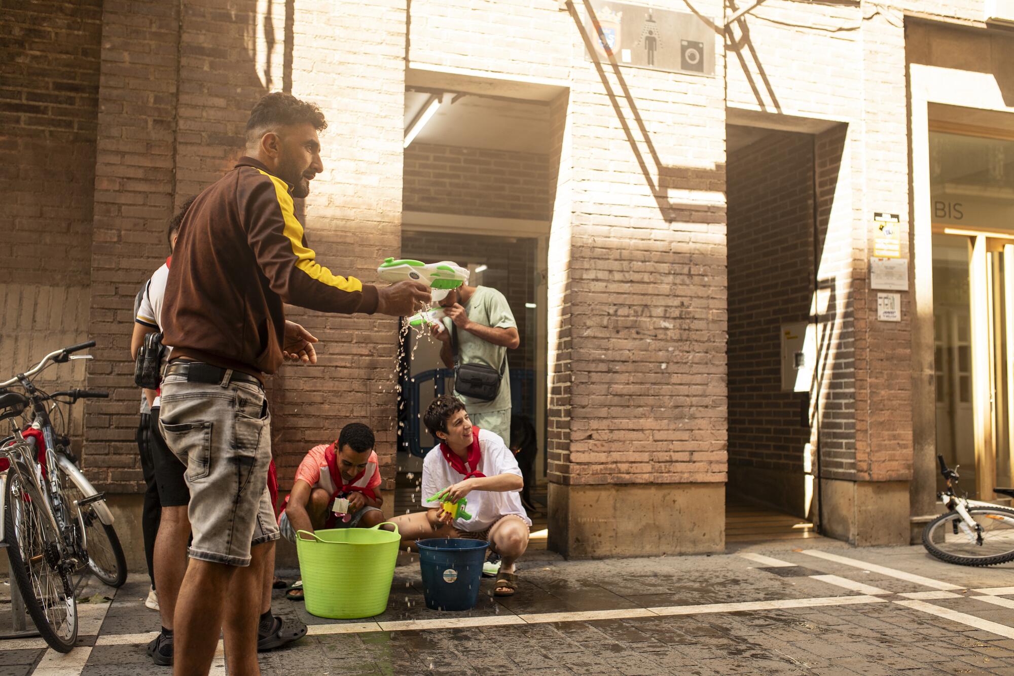 Varios activistas de Negu Gorriak/Derecho a Techo se preparan para la acción festiva de denuncia del cierre de la Casa de Baños